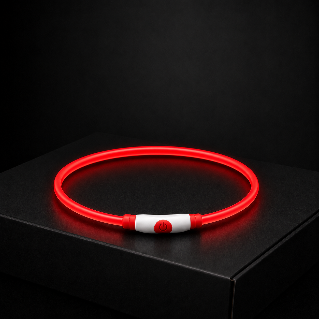 Red glowing necklace on a black surface with a dark background