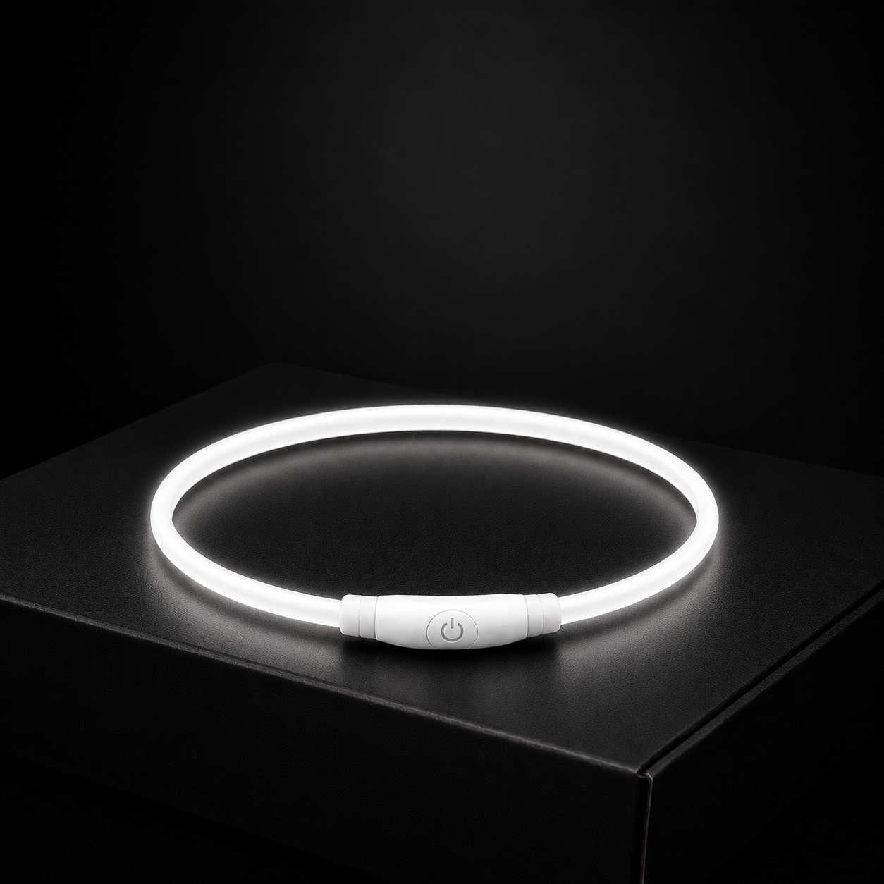Neon light necklace on a black surface with a dark background